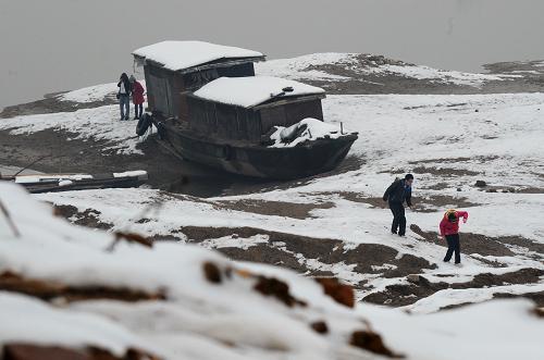 長(zhǎng)沙市民在大雪覆蓋下的湘江長(zhǎng)沙段主航道裸露的河床上走過(1月22日攝)。記者日前從從湖南省新聞辦獲悉,始于17日的罕見暴雪已給湖南省造成重大災(zāi)情,截至21日8時(shí),全省14個(gè)市州98縣區(qū)的992萬人受災(zāi),緊急轉(zhuǎn)移安置7.3萬人,飲水困難人口14.49萬人,農(nóng)作物受災(zāi)面積515千公頃,倒塌房屋8565間,損壞房屋37969間。目前,為應(yīng)對(duì)歷史罕見的暴雪,湖南省重點(diǎn)抓好“四保”工作:一保電力;二保交通;三保供應(yīng);四保民生。當(dāng)?shù)貧庀蟛块T預(yù)測(cè),受西南暖濕氣流和補(bǔ)充南下的地面冷空氣共同影響,本次降雪過程將持續(xù)到26日左右。新華社記者 龍弘濤 攝