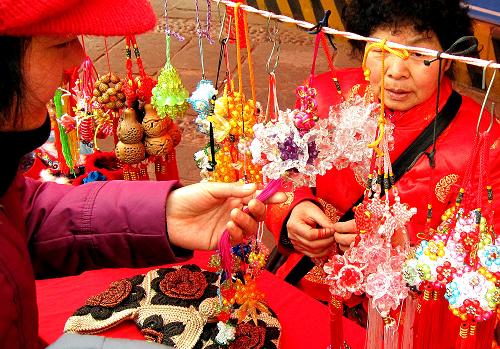 2月5日,藝術(shù)編織掛件吸引游客觀賞。當(dāng)日,是農(nóng)歷大年初三,河南鄭州市的各種廟會紅火熱鬧,不少民間藝人都在廟會上“露一手”絕活兒,深得游客喜愛。新華社記者陳飛攝