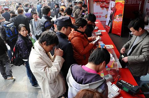 2月6日,在成都火車站前廣場(chǎng)上,旅客們?cè)谂抨?duì)使用免費(fèi)電話。新華社記者陳凱攝
