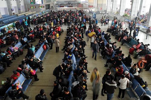2月6日,在成都火車站候車大廳內(nèi),旅客們?cè)诘群蜻M(jìn)站乘車。新華社記者陳凱攝