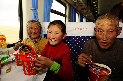 2月6日,來自四川省阿壩藏族羌族自治州的小旅客去張(中)和家人一起吃方便面。新華社記者 張宏祥 攝