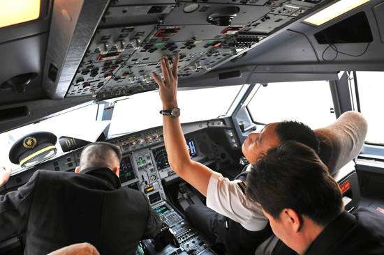 2月23日,在負責撤回利比亞中方人員的首架中國國航A330包機上,機組成員正在準備。新華社發(fā)(王澤民 攝)