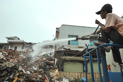 3月15日,清運(yùn)人員在對(duì)縣城一建筑物廢墟實(shí)施噴水壓塵處理。當(dāng)日,盈江地震災(zāi)區(qū)城建、環(huán)衛(wèi)等部門開始對(duì)震毀、拆除的建筑物廢墟展開專業(yè)清理、搬運(yùn),同時(shí)對(duì)現(xiàn)場(chǎng)實(shí)施噴水壓塵,并對(duì)廢棄物進(jìn)行防污染消毒處理。新華社記者陳海寧攝