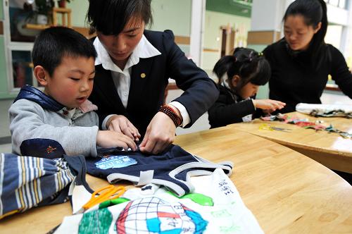 4月21日,臺州市椒江區(qū)中心幼兒園碧海明珠分園的小朋友和家長一起制作環(huán)保袋。新華社發(fā)(郟策 攝)