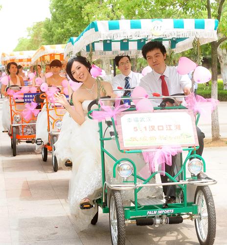 5月1日,新人騎著人力車在江灘行進(jìn),傳達(dá)低碳理念。當(dāng)日,一場以“低碳”為主題的集體婚禮在武漢江灘舉行。這場時(shí)尚簡約的集體婚禮,告別豪華鋪張的婚宴、繁瑣喧鬧的程序,在長江邊清新的自然空間,讓新人和觀看的市民享受自由自在的婚禮時(shí)光。同時(shí),新人通過植樹、騎車等方式倡導(dǎo)低碳時(shí)尚生活。新華社記者 程敏 攝