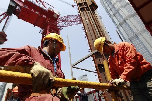 4月30日,兩名工人在上海中心大廈主樓上搭建腳手架。新華社記者 裴鑫 攝