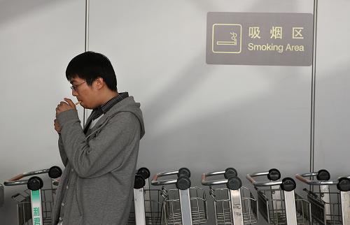 5月1日,乘客在首都機(jī)場T2航站樓吸煙區(qū)吸煙。新華社發(fā)(萬象 攝)