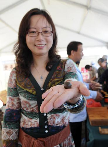 5月13日,一位市民展示自己在現(xiàn)場跟中醫(yī)師學(xué)習(xí)制作的丸藥。新華社記者 李文 攝