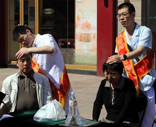 5月13日,殘疾人按摩師在為行人進(jìn)行義務(wù)按摩服務(wù)。新華社記者 唐召明 攝