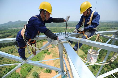 5月17日,在安徽省宣城市宣州區(qū)黃渡鄉(xiāng)境內(nèi),安徽送變電工程公司施工人員在52米高空組裝錦蘇線電力鐵塔。 新華社發(fā)(鄭賢列 攝)
