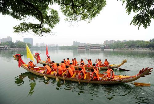 6月6日,龍舟隊(duì)員在北京龍?zhí)豆珗@湖面進(jìn)行劃龍舟表演。新華社記者 羅曉光 攝