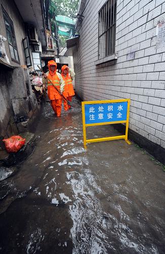6月14日,杭州市上城區(qū)紫陽街道木場巷社區(qū)的工作人員正在巡查地勢低洼的居民區(qū),防止積水進入居民家中。該街道是杭州老舊房屋較為集中的地區(qū)之一,地勢低洼,容易積水。街道已經(jīng)進入防汛二級預案,社區(qū)工作人員24小時值班,準備隨時應對暴雨可能帶來的影響。新華社記者 徐昱 攝