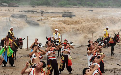 7月5日,民俗演員在黃河壺口瀑布景區(qū)表演。新華社發(fā)(閆銳鵬 攝)