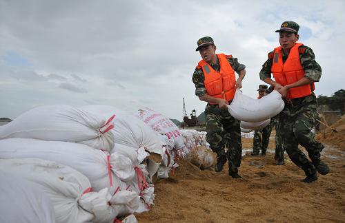 8月5日,浙江臺州邊防官兵在出現險情的堤壩上抬運沙袋搶險固堤。 當日,浙江省臺州市龍門港橫門碼頭附近堤壩受風浪侵襲出現險情。接警后,礁山邊防派出所官兵迅速趕赴現場與群眾一起加固堤壩,排除險情。據中央氣象臺預報,今年第9號強臺風“梅花”將于5日夜間進入東海東南部海域,強度緩慢加強,有可能于6日夜間到7日白天在浙江臺州到江蘇啟東一帶沿海登陸。 新華社發(fā)(郟策 攝)