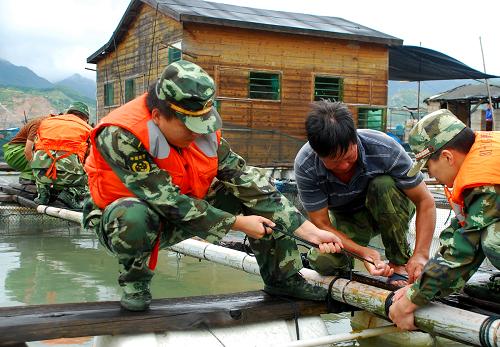8月29日,在福建寧德三都青山海域,邊防民警與漁民一起加固魚(yú)排。新華社發(fā)(袁自由 攝)