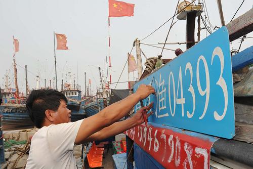 8月31日,一名漁民在天津市濱海新區(qū)蔡家堡碼頭安裝漁船號牌。新華社記者岳月偉攝