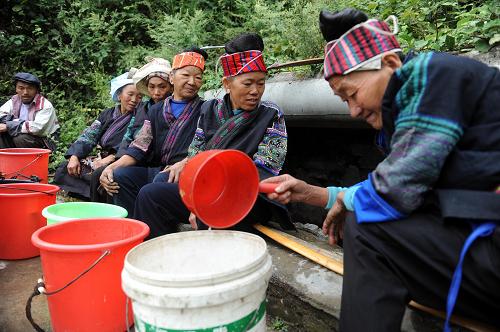 貴灑村村民徐計降(右一)在打水,其他村民在等待。由于干旱,泉水出水很慢,村民們打水要排隊,等待一個小時也僅能裝上小半桶水(9月23日攝)。位于貴州省黔東南州鎮(zhèn)遠(yuǎn)縣報京鄉(xiāng)的貴灑村,居住著380多戶苗族、侗族群眾1840多人,是鄉(xiāng)里最窮的村子。雖然近年來,村里修通了公路,修建了學(xué)校、活動室和衛(wèi)生室,面貌有了起色,但今年又遭遇嚴(yán)重干旱。目前,貴灑村4個自然村寨均出現(xiàn)飲水困難,在最困難的貴灑大寨和貓溝寨里,僅有的兩口水井水量極小,每口井積攢24小時也僅有100公斤左右水量,不能滿足186戶群眾生活的需要。雖然水少,但村民們相互體諒,打水秩序井然。新華社記者 劉力航 攝