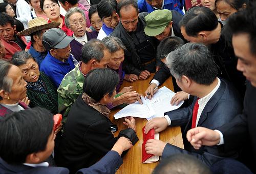 9月26日,湖北宣恩縣珠山鎮(zhèn)的老年人在首發(fā)式上領(lǐng)取社會(huì)養(yǎng)老保險(xiǎn)金存折。新華社發(fā)(宋文 攝)