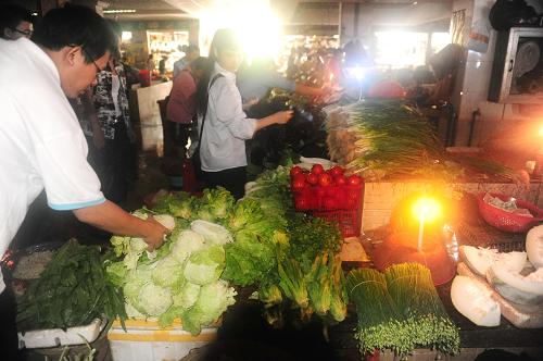9月30日,在海南瓊海市一處因臺風(fēng)造成停電的農(nóng)貿(mào)市場內(nèi),菜販們在燭光中恢復(fù)向居民供應(yīng)蔬菜。新華社發(fā)(蒙鐘德 攝)