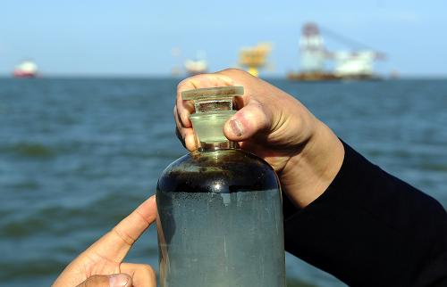 這是10月15日從遼東灣北部錦州9-3油田附近的溢油帶海面提取的水樣。新華社發(fā)(李雨澤 攝)