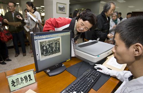 10月16日,在“檔案館日”活動(dòng)上,北京市檔案館工作人員為市民免費(fèi)修復(fù)老照片。當(dāng)日,北京市檔案館舉辦第三屆“檔案館日”活動(dòng)。本屆“檔案館日”主題是“檔案為您服務(wù)”,市民可以參觀多種富有地域特色的檔案展覽,體驗(yàn)檔案查詢和政府信息公開查閱服務(wù),觀摩檔案修裱、數(shù)字化制作等專業(yè)工作流程,聆聽各類檔案知識(shí)、檔案文化的講座,與檔案館零距離接觸,親身感受現(xiàn)代檔案館與公眾生活的緊密聯(lián)系。新華社發(fā)(趙冰 攝)
