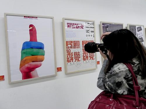10月19日,參觀者在中國美術(shù)學(xué)院美術(shù)館拍攝公益廣告畫《青春·使命·色彩》。新華社發(fā)(龍巍 攝)