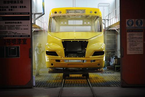 工人在為“最牛校車”車體噴漆(12月22日攝)。新華社記者 李健 攝
