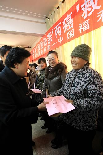 1月17日,甘肅省婦聯(lián)副主席朱玉蘭(左)在為一位“貧困母親”發(fā)放“貧困母親兩癌救助專項(xiàng)基金”。新華社記者 李明放 攝