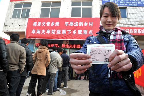 2月3日,在安徽省阜陽市臨泉縣譚棚鎮(zhèn),一位旅客在展示工作人員送來的火車票。新華社記者 郭晨 攝
