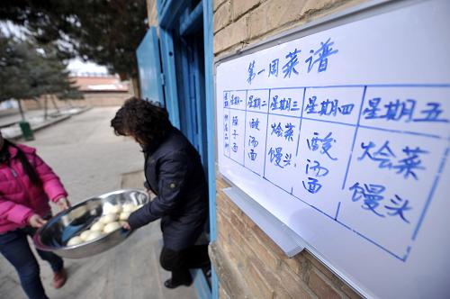 2月17日,在寧夏回族自治區(qū)隆德縣鳳嶺鄉(xiāng)馮碑小學內,老師正在領取學生們的免費午餐。新華社記者 彭昭之 攝