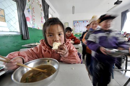 2月17日,在寧夏回族自治區(qū)隆德縣鳳嶺鄉(xiāng)馮碑小學二年級的教室內,一位學生正在吃免費午餐,她的幾位同學正忙著去添第二碗。新華社記者 彭昭之 攝