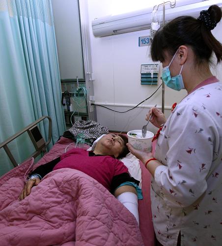 2月18日,花蓮醫(yī)院的護(hù)理人員在給輕傷患者高振娥女士喂飯。2月17日18時(shí),一輛隸屬臺灣美利達(dá)旅行社世晟公司車號為59-BB游覽車行駛到花蓮縣豐濱鄉(xiāng)臺11線43.5公里處發(fā)生翻車,造成9人重傷,22人輕傷。據(jù)臺灣花蓮縣警方公布的調(diào)查結(jié)果顯示,翻車事故系司機(jī)超速所致。大陸游客團(tuán)多數(shù)成員均被送往醫(yī)院接受救治。新華社記者 高學(xué)余 攝
