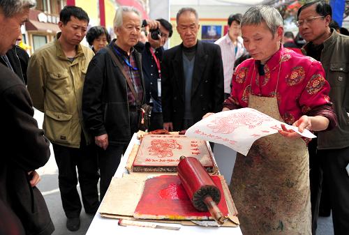 4月6日,一位來自四川的民間藝人在展示木版畫印刷的技藝。 當(dāng)日,第三屆西部非物質(zhì)文化遺產(chǎn)展演暨西安文化產(chǎn)業(yè)洽談會開幕,來自西部各個省市自治區(qū)的百余位代表帶著當(dāng)?shù)氐膰鴮毤壏俏镔|(zhì)文化遺產(chǎn)項目亮相西安大唐西市,向人們展示優(yōu)秀的民間文化。新華社記者 劉瀟 攝