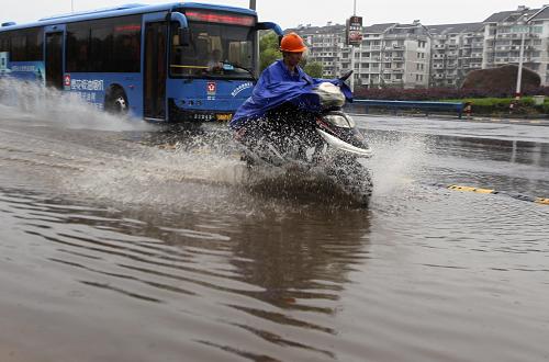 6月17日,浙江紹興市降下大雨,居民在街頭涉水前行。新華社發(fā)(梁永鋒 攝)