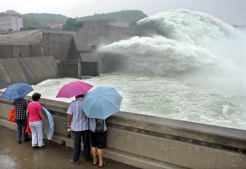 6月27日,幾位游客冒著細(xì)雨在觀賞小浪底“飛瀑”。新華社記者 王頌 攝