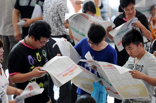 7月21日,求職者在連云港市夏季人才交流大會上觀看招聘信息。新華社發(fā)(耿玉和 攝)