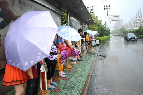 8月3日,市民在雨中等待公交車。 當(dāng)日,受今年第九號(hào)臺(tái)風(fēng)“蘇拉”和第十號(hào)臺(tái)風(fēng)“達(dá)維”外圍云系的影響,合肥市區(qū)降下大雨,這場大雨也“澆滅”了合肥持續(xù)了十幾日的高溫酷暑天氣,氣溫降至35攝氏度以下。據(jù)合肥市氣象部門預(yù)報(bào),未來3天合肥將持續(xù)陣雨天氣。新華社記者 杜宇 攝