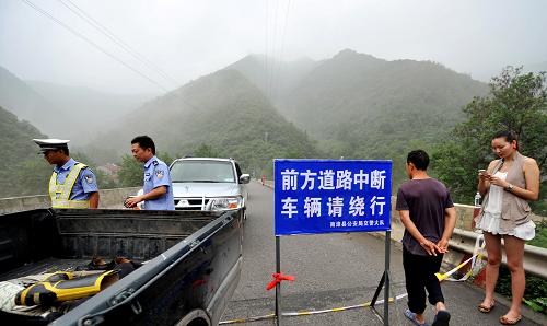 8月6日,交警在因洪災中斷的305省道上開展分流疏散工作。新華社發(fā)(熊明銀 攝)