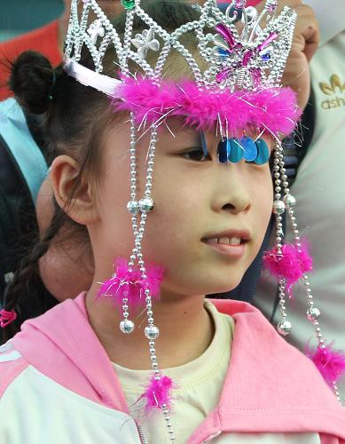 8月26日,一個(gè)小女孩戴著在北京買的裝飾品,來到北京西站,踏上回家的旅程。新華社發(fā)(王全超 攝)