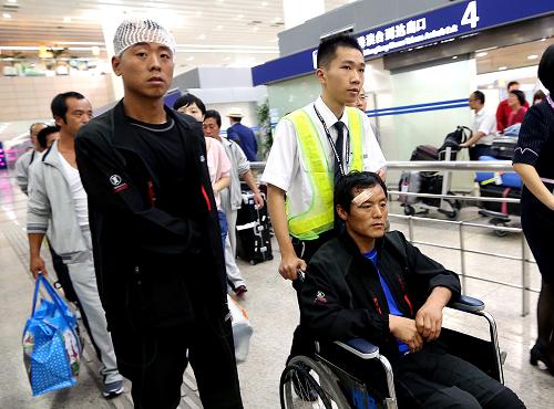 8月31日,遇險負傷的中國船員李波(前左一)、張順利(前右一)走出上海浦東國際機場到達出口。新華社記者 陳飛 攝