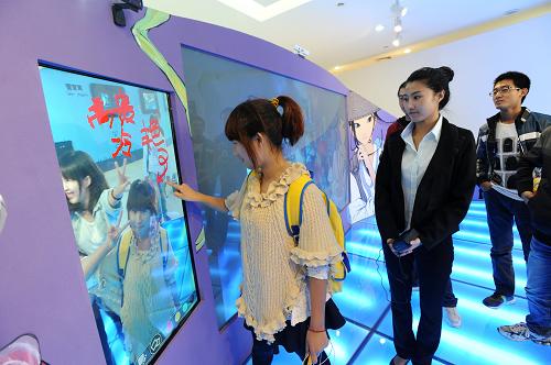 10月27日,參觀者在國(guó)家動(dòng)漫產(chǎn)業(yè)園展示中心體驗(yàn)電子簽名墻。新華社發(fā)(周偉 攝)