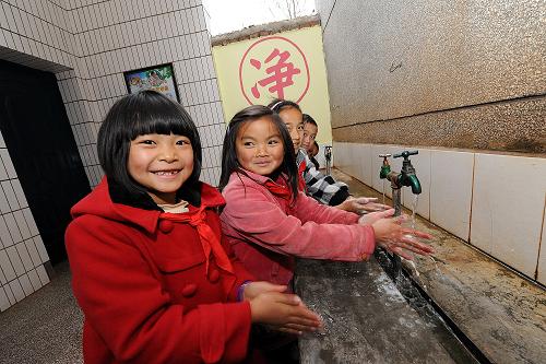 云南省新平縣費(fèi)賈小學(xué)的孩子們?cè)谖顼埱跋词郑?011年12月15日攝)。自從2010年“母親水窖”安全飲水進(jìn)校園項(xiàng)目實(shí)施以來(lái),學(xué)校里建起水沖廁所,安裝了太陽(yáng)能凈水機(jī)。新華社記者 何俊昌 攝