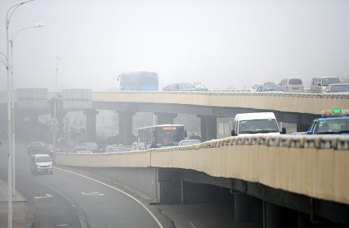 11月19日,車(chē)輛行駛在大霧籠罩下的南昌市八一大橋。新華社記者 周科 攝