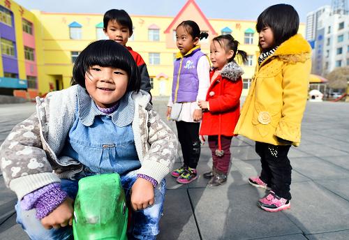 11月15日,青海黃南州幼兒園內(nèi),高玉軒(前)和小伙伴們在玩木馬。新華社發(fā)(吳剛 攝)
