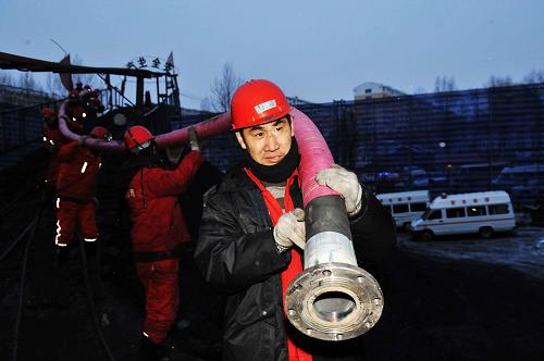 12月2日,救援人員在井口旁運送排水管。調試好的兩臺水泵在2日下午形成排水能力。新華社記者 王建威 攝