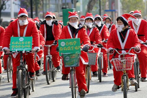 12月19日,中學(xué)生裝扮成“圣誕老人”在南通街頭騎行,向市民宣傳低碳環(huán)保理念。新華社發(fā)(丁曉春 攝)