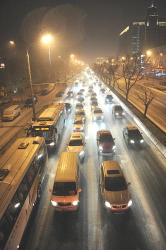 12月20日,宣武門內(nèi)大街的車流在雪中緩慢前行。新華社發(fā)(賀燦鈴 攝)