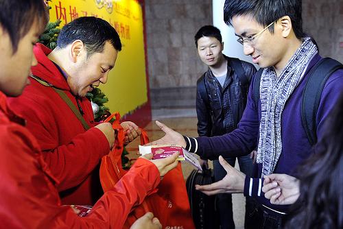 12月23日,內(nèi)地購(gòu)物團(tuán)成員在領(lǐng)取展會(huì)門票。新華社記者 陳曉偉 攝