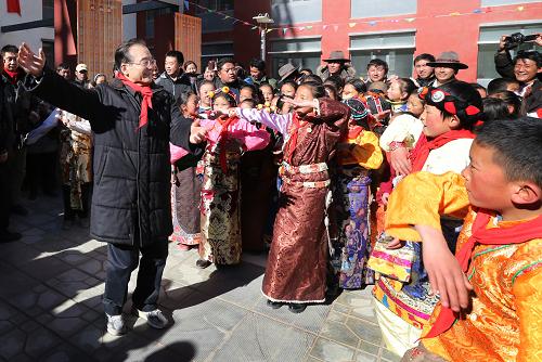 這是2012年12月31日,溫家寶在玉樹災(zāi)后重建的紅旗小學(xué)與孩子們一起跳藏族舞蹈。 新華社記者姚大偉攝