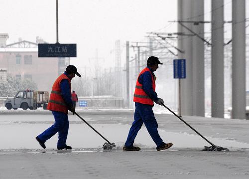 1月4日,九江車務(wù)段工作人員在九江火車站清掃站臺上的積雪。 新華社發(fā)(胡國林 攝)